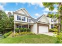 Two-story home featuring brick accents, white siding, manicured landscaping, and an attached two-car garage at 213 Florence Dr, Clayton, NC 27527