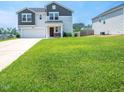 Spacious front yard with lush green grass, complemented by the house and driveway, offers curb appeal at 221 Hallow Oak St, Spring Lake, NC 28390
