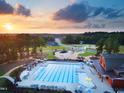 Aerial view of the community pool area featuring clear blue water, lounge chairs, and vibrant landscaping at 253 Inspiration Way, Fuquay Varina, NC 27526