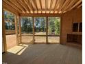 Screened-in back porch with wood flooring and view of lush greenery, enhancing outdoor living space and comfort at 253 Inspiration Way, Fuquay Varina, NC 27526