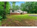 Well-kept single-story home featuring a brick base, traditional siding, and inviting front steps, surrounded by mature trees at 2832 Ladale Ln, Mebane, NC 27302