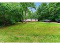 Inviting single-story home nestled in a wooded area, featuring a well-manicured lawn, and a private driveway at 2832 Ladale Ln, Mebane, NC 27302