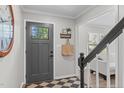 Inviting foyer with a stylish door, black and white checkered floor mat, and staircase leading to the upper level at 3 Haggis Ct, Durham, NC 27705