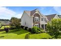 Two-story home featuring stone accents and shutters, with a well-maintained lawn and lush landscaping at 30 Sunbury Ct, Zebulon, NC 27597