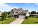 Beautiful two-story home with a well-kept lawn, two-car garage, stone accents, and manicured landscaping at 30 Sunbury Ct, Zebulon, NC 27597