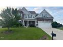 Charming two-story home with stone and siding, lush lawn, and a two-car garage at 30 Sunbury Ct, Zebulon, NC 27597