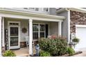 Welcoming front porch with rocking chairs, decorative plants, and tasteful decor providing an inviting entry at 30 Sunbury Ct, Zebulon, NC 27597