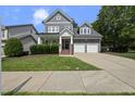 Inviting two-story home featuring a two-car garage, and a covered front porch with manicured landscaping at 300 Redhill Rd, Holly Springs, NC 27540