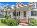 Inviting front porch with decorative iron railings, brick flooring, and lush landscaping at 302 Hester St, Knightdale, NC 27545
