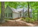 Inviting home exterior with manicured landscaping, a welcoming entrance, and a peaceful wooded backdrop at 304 W Kirkfield Dr, Cary, NC 27518