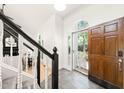 Bright foyer with elegant staircase and a wood front door leading to outside at 304 W Kirkfield Dr, Cary, NC 27518