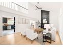 Open-concept living room with a fireplace, a high ceiling, and seamlessly connected spaces to kitchen at 304 W Kirkfield Dr, Cary, NC 27518