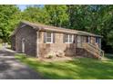 Brick home featuring black shutters, landscaping, and a driveway, set on a grassy lot at 3329 Broughton Dr, Durham, NC 27704