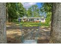 Distant view of a one-story home, framed by mature trees at 418 S West St, Cary, NC 27511