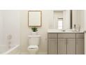 Bright bathroom featuring a gray vanity, a white toilet, and bathtub with shower at 43 Regal Gardens Ct, Angier, NC 27501