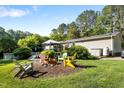 Spacious backyard featuring a cozy seating area, mature trees and landscaping at 4701 Governor Hunt St, Efland, NC 27243