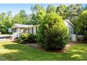 Landscaped yard with lush trees and green lawn surrounding home's exterior at 4701 Governor Hunt St, Efland, NC 27243