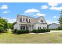 Charming two-story home featuring white siding, black shutters, and a welcoming front porch at 509 Spruce Meadows Ln, Willow Springs, NC 27592