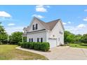 Classic two-story home with attached garage, complemented by lush landscaping at 509 Spruce Meadows Ln, Willow Springs, NC 27592