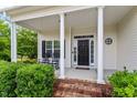 Inviting front porch with white columns and two rocking chairs at 509 Spruce Meadows Ln, Willow Springs, NC 27592