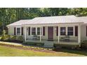 Inviting covered front porch with seating, beautiful landscaping, and charming curb appeal at 560 Parker Creek Rd, Holly Springs, NC 27540