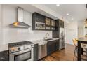 Modern kitchen featuring stainless steel appliances, dark cabinetry, and white subway tile backsplash at 601 W Rosemary St # 715, Chapel Hill, NC 27516