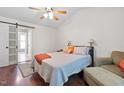 Cozy bedroom features a queen-sized bed, a sliding barn door leading to an attached bathroom, and a neutral color scheme at 687 W Watson Rd, Benson, NC 27504