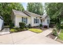 Charming single-story home with a well-maintained lawn, mature trees, and a concrete driveway at 687 W Watson Rd, Benson, NC 27504