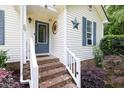 Charming front porch with brick steps, decorative door accents, and beautiful landscaping at 687 W Watson Rd, Benson, NC 27504