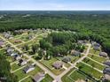 Stunning aerial view of a residential neighborhood surrounded by lush greenery and tranquil pond at 7801 Charters End St, Willow Springs, NC 27592
