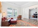Cozy living area with a leather chaise lounge, large windows and stylish rug providing comfort and natural light at 7801 Charters End St, Willow Springs, NC 27592