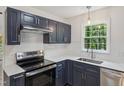 Modern kitchen with navy cabinets, stainless steel appliances, white subway tile, and quartz countertops at 856 Williams White Rd, Zebulon, NC 27597