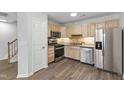 Kitchen features stainless steel appliances, wood cabinets, and sleek countertops at 8610 Neuse Landing Ln # 103, Raleigh, NC 27616