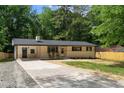 Charming single-story home with a long driveway, rocking chairs, and manicured front yard at 908 W Garden St, Sanford, NC 27330