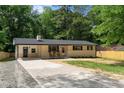 Charming single-story home with a long driveway, rocking chairs, and manicured front yard at 908 W Garden St, Sanford, NC 27330