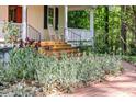 Charming home exterior with front porch, manicured landscaping, and brick pathway at 9417 Greenfield Dr, Raleigh, NC 27615