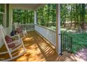 Inviting porch features wooden floors, comfortable rocking chairs, and a serene wooded backdrop at 9417 Greenfield Dr, Raleigh, NC 27615