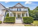 Stunning home featuring a welcoming front porch with white columns and manicured hedges, inviting guests at 1001 Dairy House Ct, Wake Forest, NC 27587