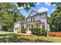 Inviting two-story home featuring white painted brick, black shutters, and a charming front porch at 1001 Dairy House Ct, Wake Forest, NC 27587