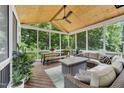Relaxing screened porch with wood-paneled ceiling, comfortable seating, and a stylish outdoor rug at 1001 Dairy House Ct, Wake Forest, NC 27587
