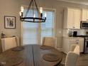 Cozy dining area with wood table, light fixture, and bright windows provides a great eating space at 1006 Starkville St, Durham, NC 27713
