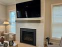 Cozy living space with a modern fireplace, large television, and a bright window at 1006 Starkville St, Durham, NC 27713