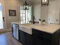 Modern kitchen features a white farmhouse sink and sleek black cabinets, creating a stylish and functional space at 1006 Starkville St, Durham, NC 27713