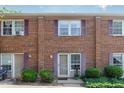 Brick townhome featuring symmetrical design, vibrant purple shutters, and well-manicured greenery at 103 Coleridge Ct, Carrboro, NC 27510