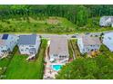 Aerial view of a home with a private backyard oasis, including a sparkling pool and outdoor seating area at 113 Hidden Bluff Dr, Chapel Hill, NC 27517