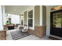 Cozy front porch with stone accents, decorative columns, and comfortable seating for relaxing outdoors at 113 Hidden Bluff Dr, Chapel Hill, NC 27517