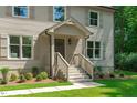 Close-up of front porch with brick stairs, white railings, and a stylishly painted front door and manicured landscaping at 11817 Coachmans Way, Raleigh, NC 27614
