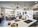 Bright, open-concept kitchen features modern lighting, stainless appliances, and center island at 1205 Bridgeforth Ln, Chapel Hill, NC 27517