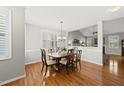 Sunlit dining area with hardwood floors, chandelier, and a view into the spacious living room at 12505 Garden Tree Ln, Raleigh, NC 27614