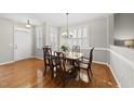 Elegant dining room featuring hardwood floors, wainscoting, shutters, and a chandelier at 12505 Garden Tree Ln, Raleigh, NC 27614